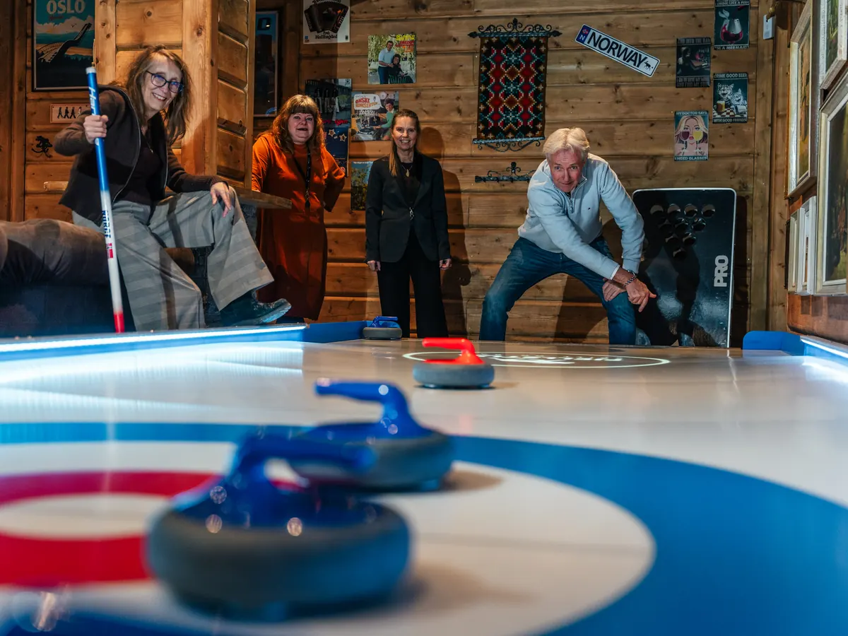 Gjester som spiller streetcurling i bar