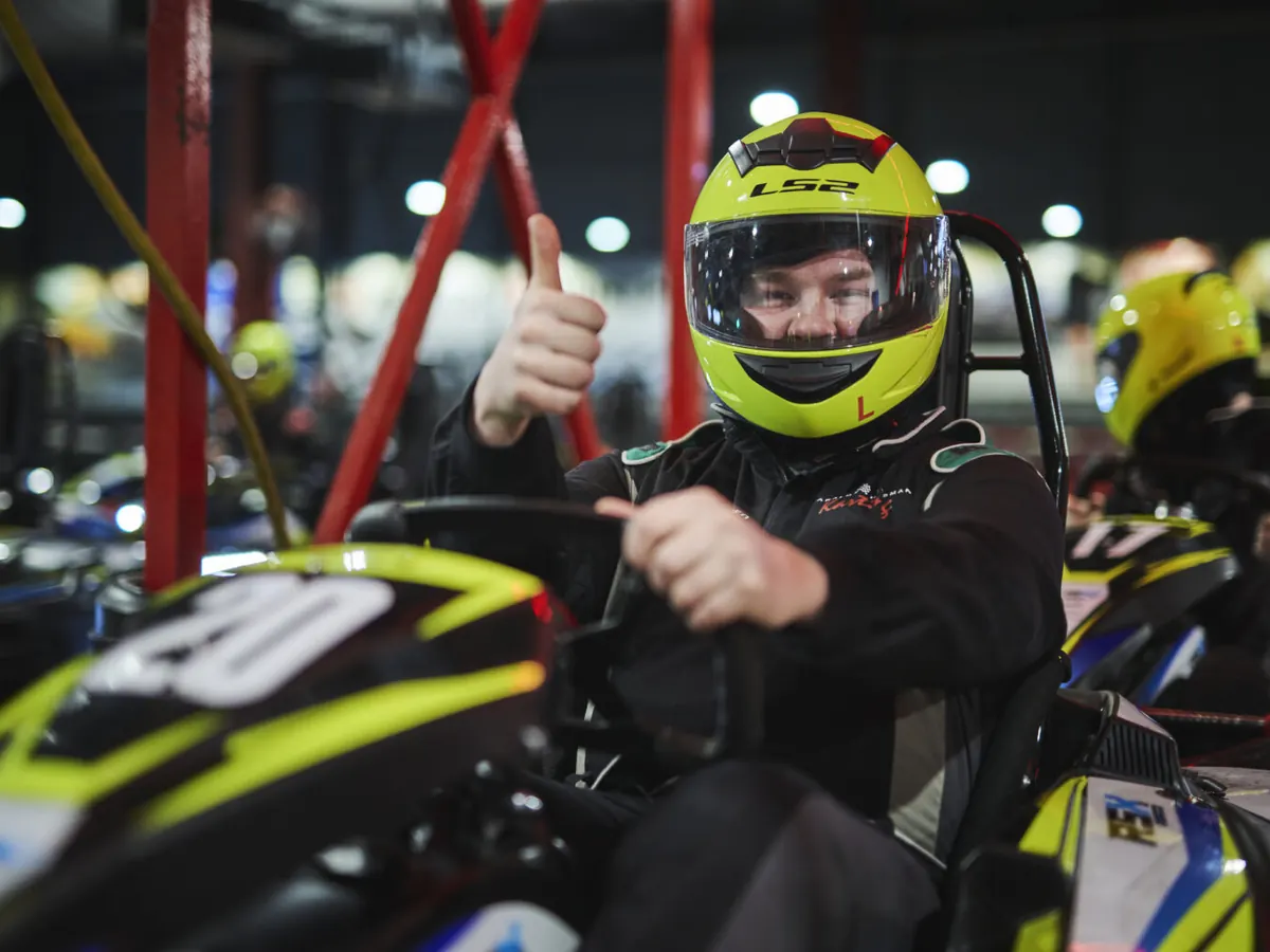 Fører med hjelm i gokart gir tommel opp